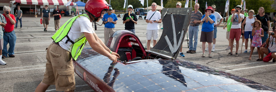 A student prepares to enter his solar powered car.