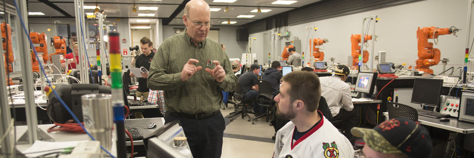 A teacher instructs his student in a tech lab