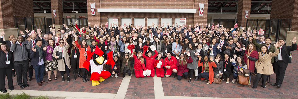 Group of employees in front of Hancock Stadium with Reggie