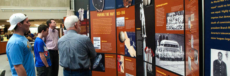 Students and teachers read and enjoy an exhibit on display at the library.