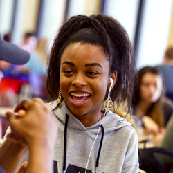 A students smiles inside a dining hall.