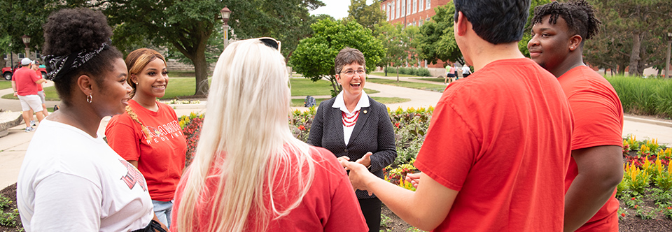 Dr. Kinzy talking to students on the quad