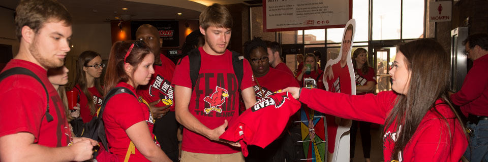 A group of students wearing ISU shirts win a new 'Fear the Bird' shirt.